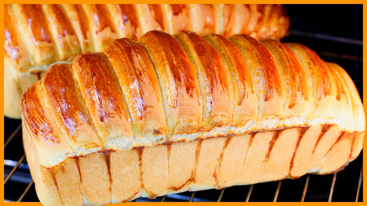 Pão caseiro fofinho já fatiado em uma tábua de madeira
